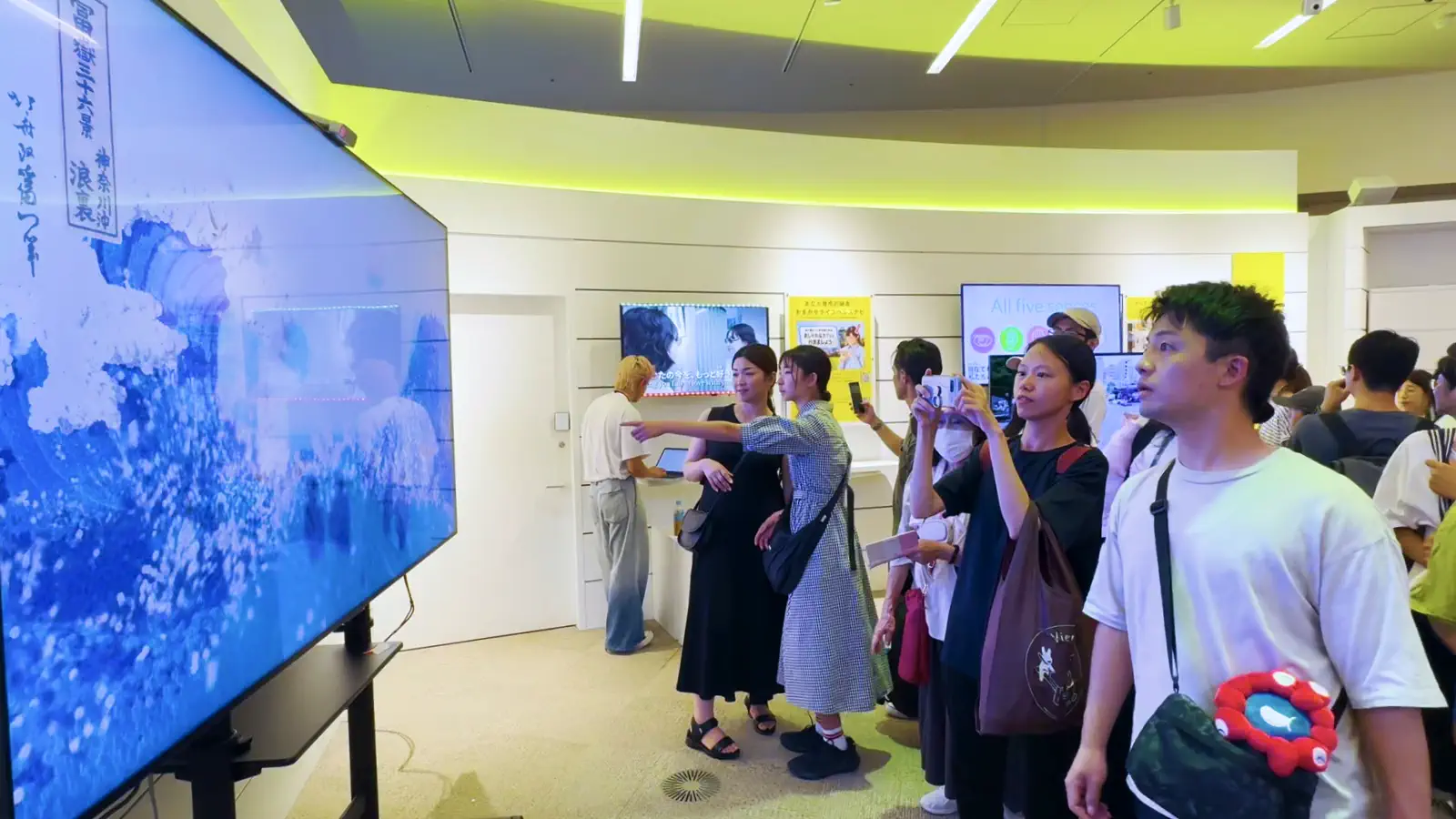 Children and adults playing with the wave in front of the interactive screen